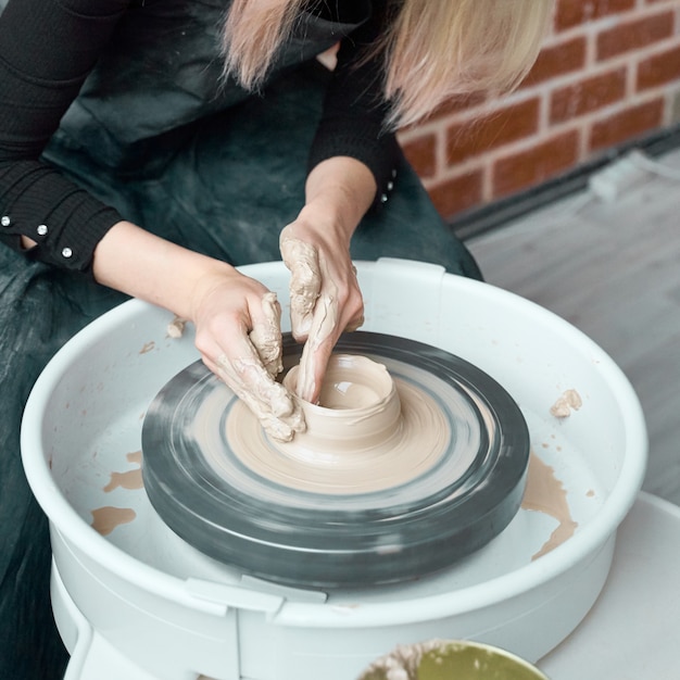 Woman making ceramic pottery on wheel