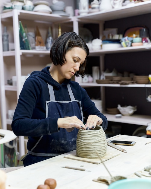 Woman making ceramic pottery on workshop. Concept for woman in freelance, business. Handcraft