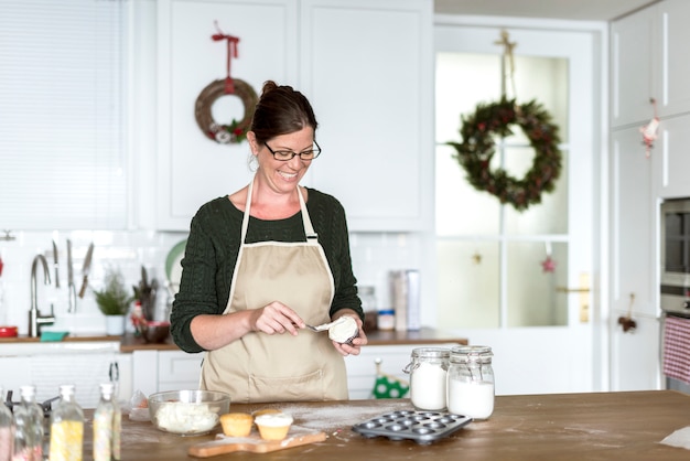 Woman making Christmas cupcakes