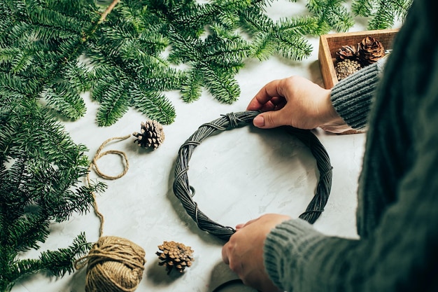 Woman making a christmas fir wreath Christmas decorating for home interior