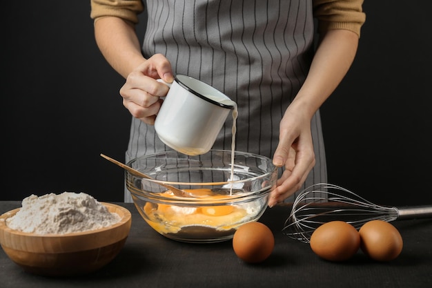 Woman making dough on kitchen table