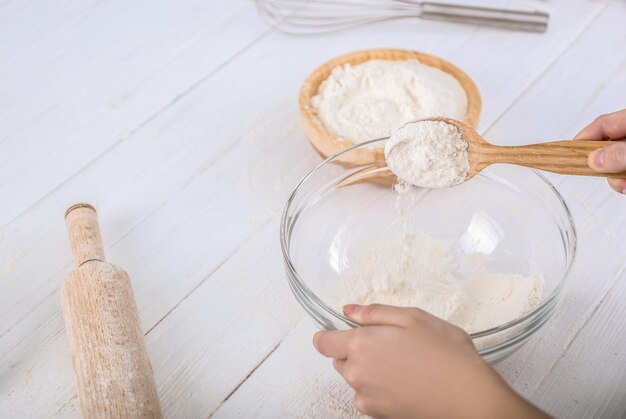 Woman making dough on kitchen table