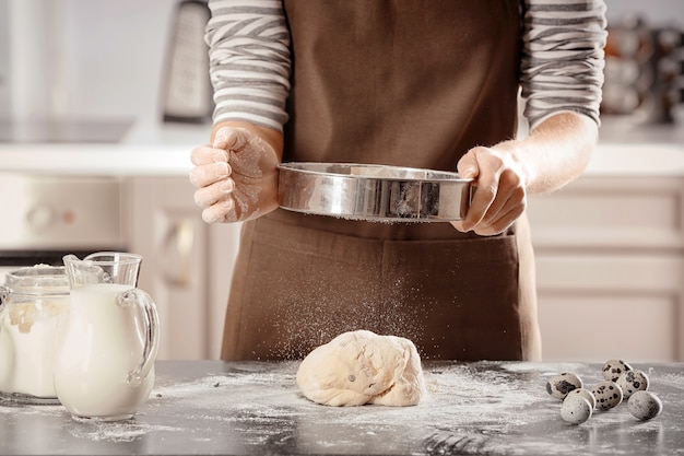 Woman making dough on table