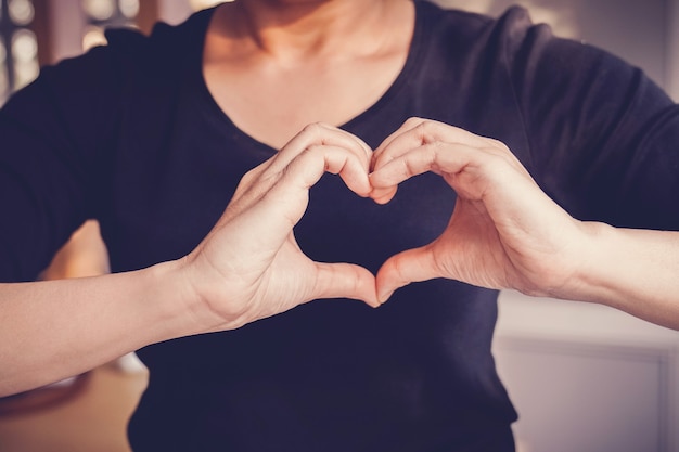 Woman making hands in heart shape sign, world heart day