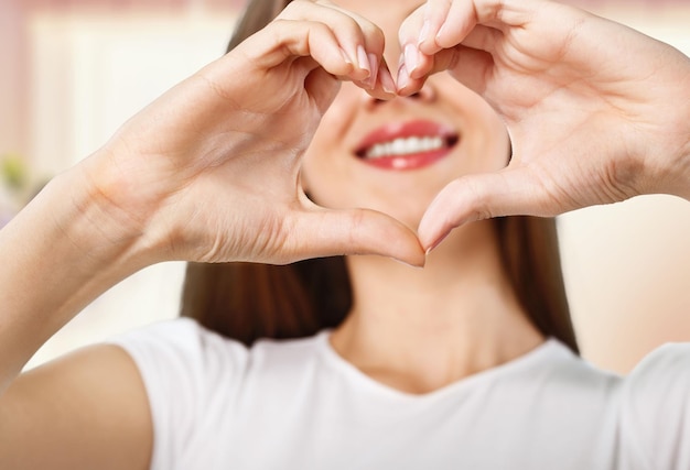 Woman making a heart shape with her hands - isolated over white