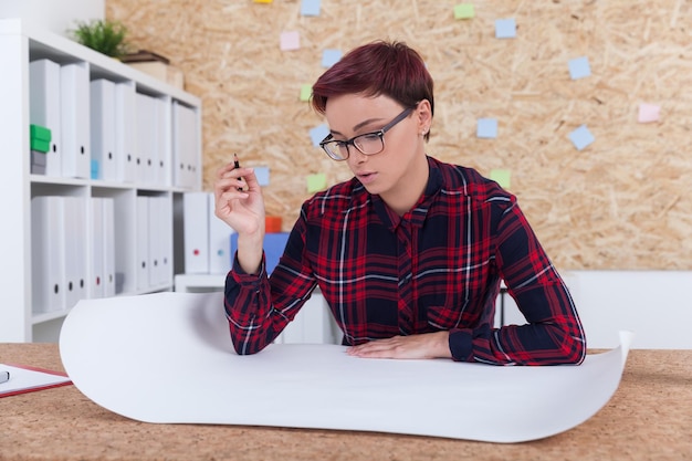 Woman making marks in blueprint