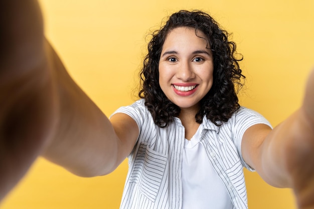 Woman making point of view phone looking with toothy smile expressing happiness