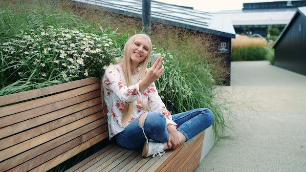 Woman making video call on green roof.