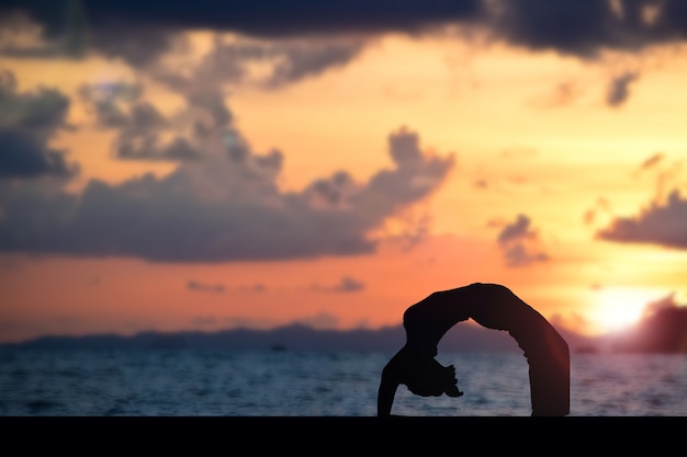 Photo woman making yoga on the beach