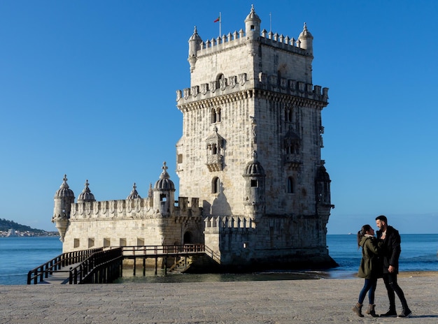 Woman and man next to the Belem Tower in Lisbon Portugal