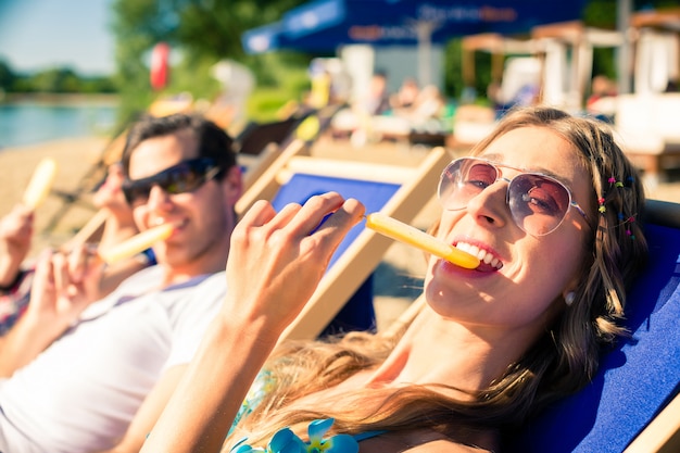 Woman and man eating ice cream on beach