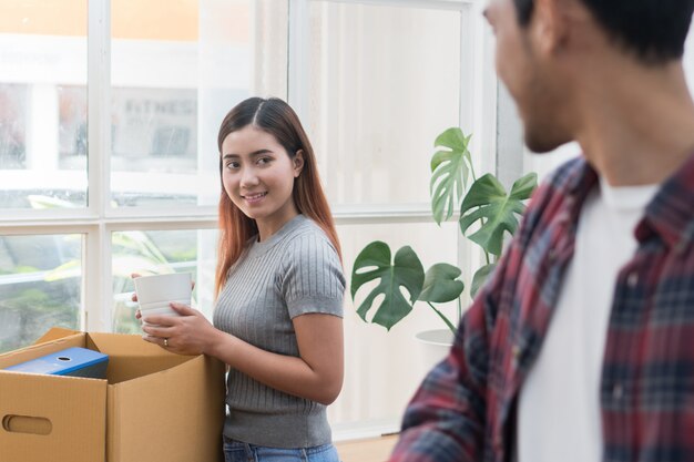 Woman and man unpacking messy boxes.