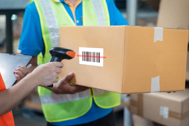 Woman manager professional smiling of warehouse logistic worker job check scanning barcode on parcel box in distribution factory logistic business