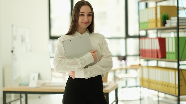 Woman manager with clipboard in hands in office portrait