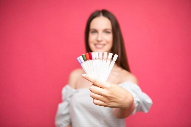 woman manicure master showing nail polish palettes on plastic samplers. choosing nail color