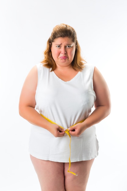 Woman measuring her waist with tape