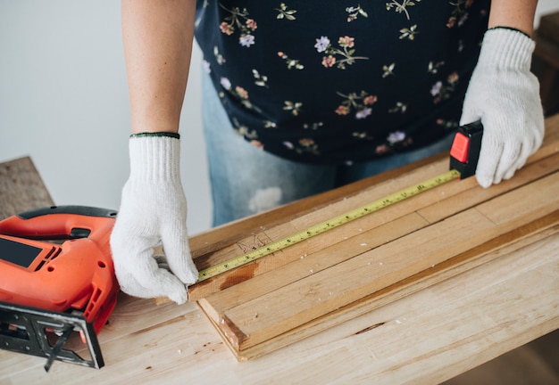 Woman measuring a wooden plank