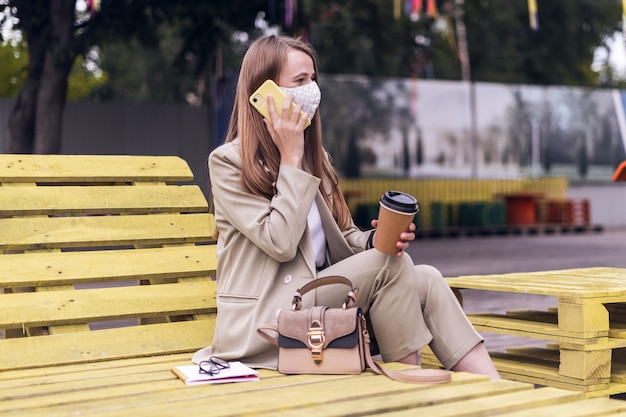 Woman in medical face mask talking over the phone