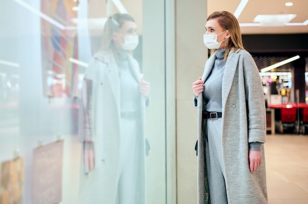 Woman in medical masks is shopping in grocery store during virus pandemic