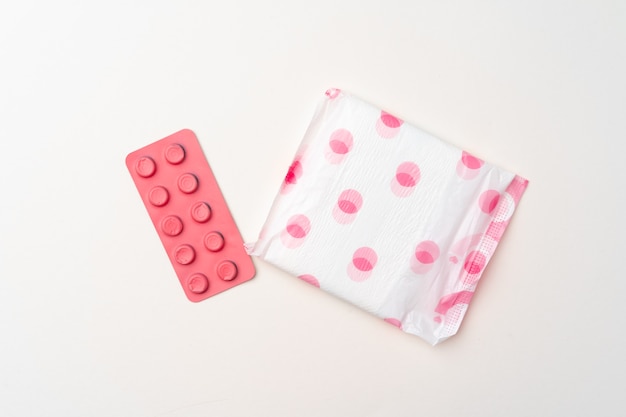 Woman medical pad and painkiller pills top view