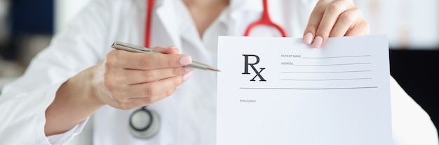 Woman medicine doctor holding hand gives prescription to patient closeup