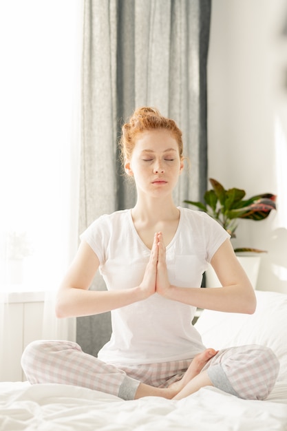 Woman meditating over the bed