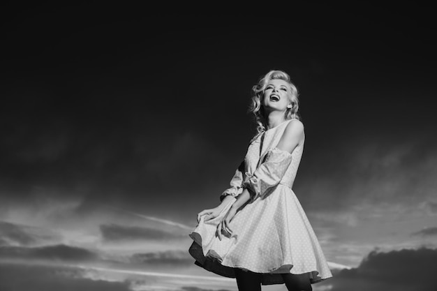 Woman in monroe dress on dramatic sky fashionable young model in style dress fashion woman in summer