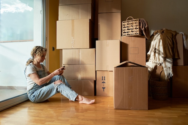 Woman move in real estate rental positive looking at relocation or unpacking cardboard package enjoy