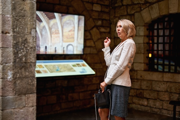 Photo woman in museum uses touchscreen monitor electronic guide