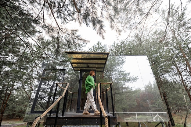 Woman near an invisible house in pine forest