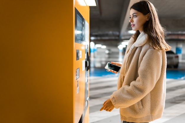 Woman near terminal in the underground parking