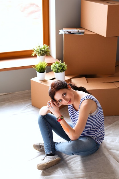 Woman in a new home with cardboard boxes Woman in the house