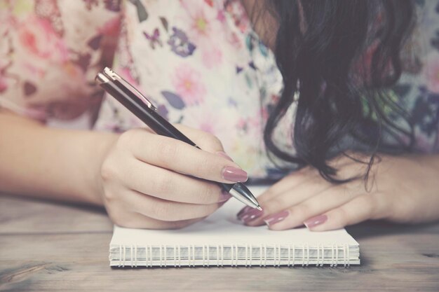 Woman and notepad on wooden table