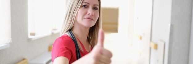 Woman nurse in hospital corridor showing thumbs up