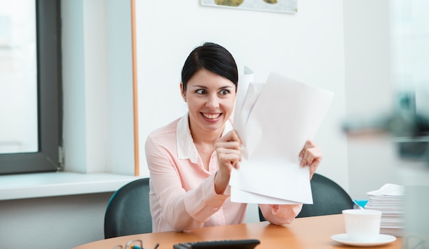 Woman in office with crumpled paper. Office life concept.