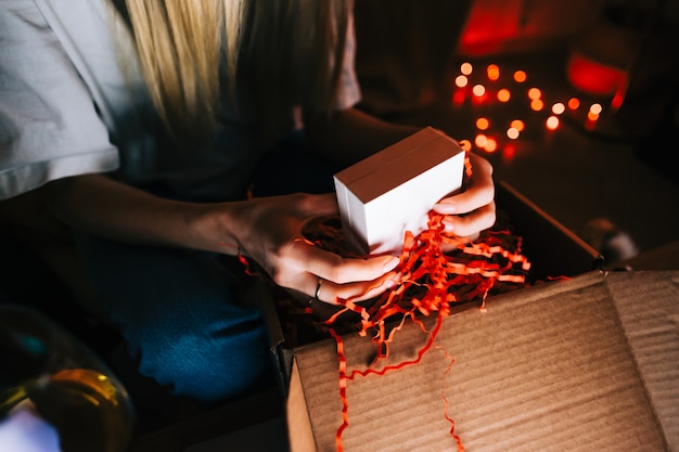 Woman open gift during video call on laptop computer and drinking wine, use technology for communicate with friends or family.