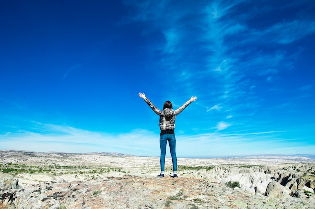 Woman open her arms in the mountain