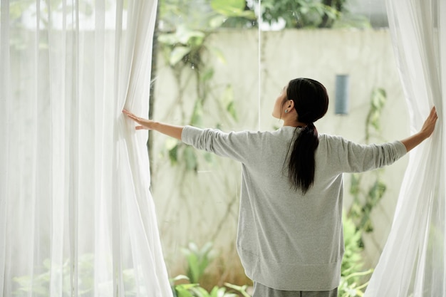 Woman Opening Curtains