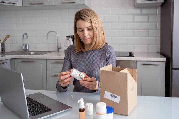 A woman opens a box with biologically active additives Ordering food additives via the Internet