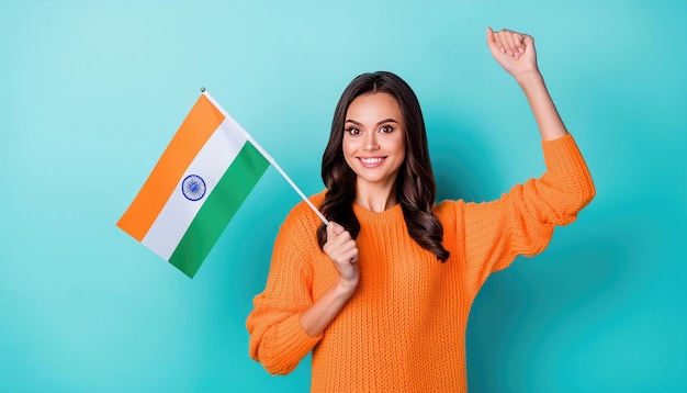 A woman in an orange sweater holds an Indian flag