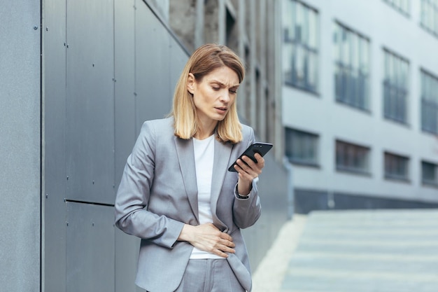 Woman outside the office has severe abdominal pain tries to call the doctor uses the phone