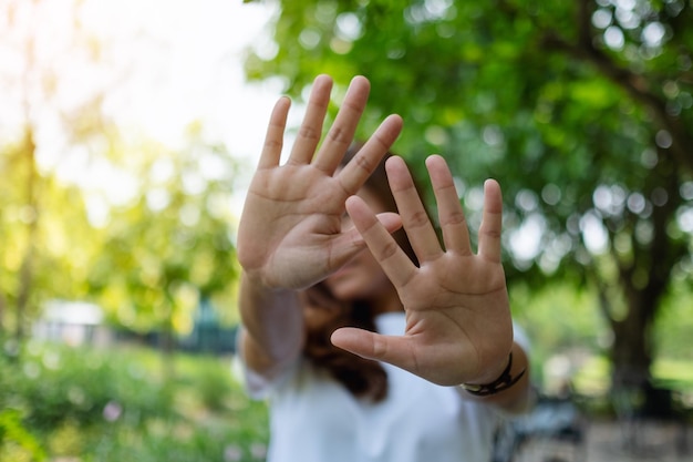 A woman outstretched hand and showing stop hand sign