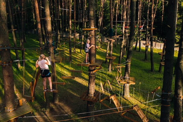 A woman overcomes an obstacle in a rope town A woman in a forest rope park