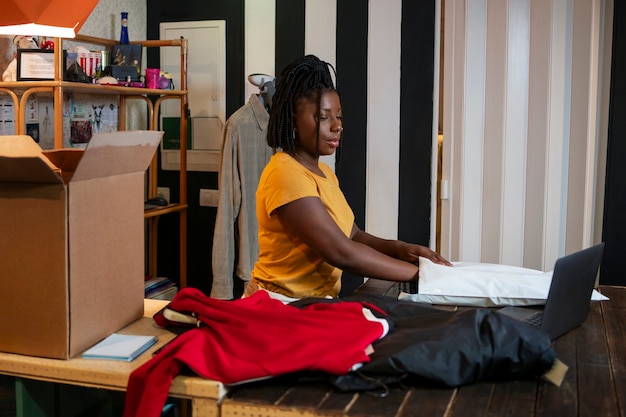 Woman packaging clothing in thrift store