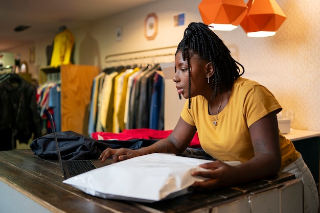 Woman packaging clothing in thrift store