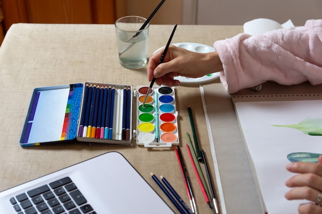 Woman painting with watercolors at home