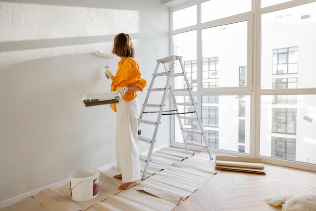 Woman paints wall renovating her apartment