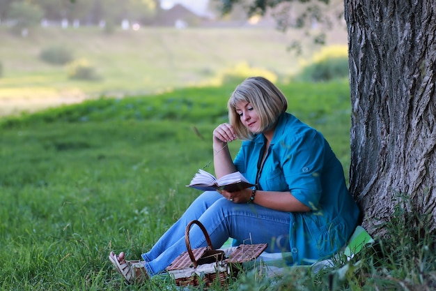 woman in the park tree reading book