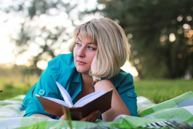 Woman in park with book on the grass