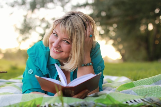 Woman in park with book on the grass